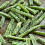 A batch of homemade green bean crunchies for dogs, crispy and nutritious, laid out on a baking sheet.