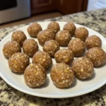 A bowl filled with homemade Pumpkin and Apple Balls for Dogs, made with healthy ingredients like pumpkin, apple, peanut butter, and oats.